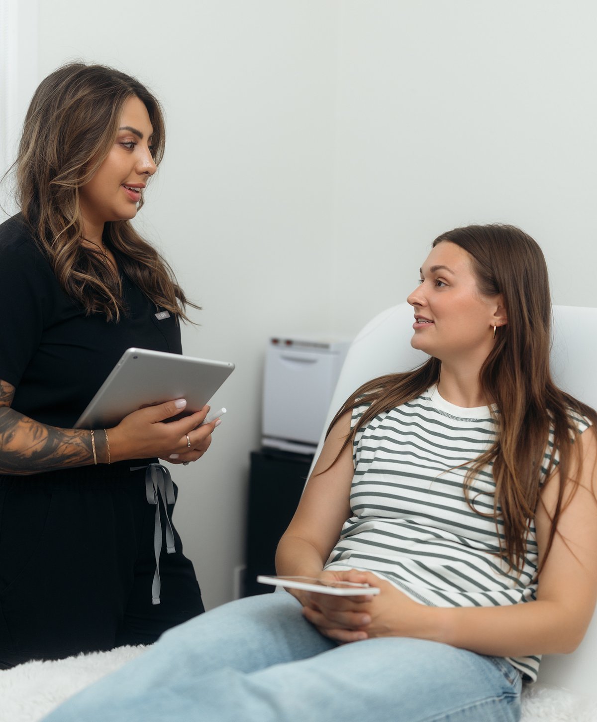 Licensed esthetician talking through a skin assessment with a client at Boulder Skin Bar