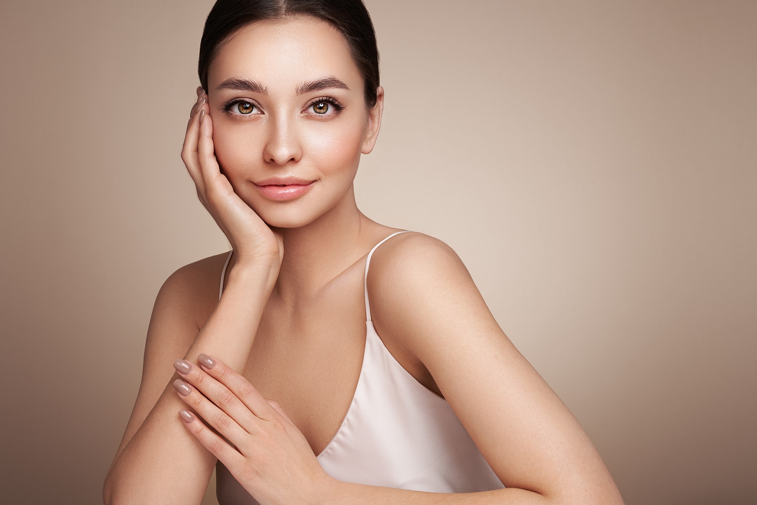 Smiling woman with glowing skin and natural makeup.