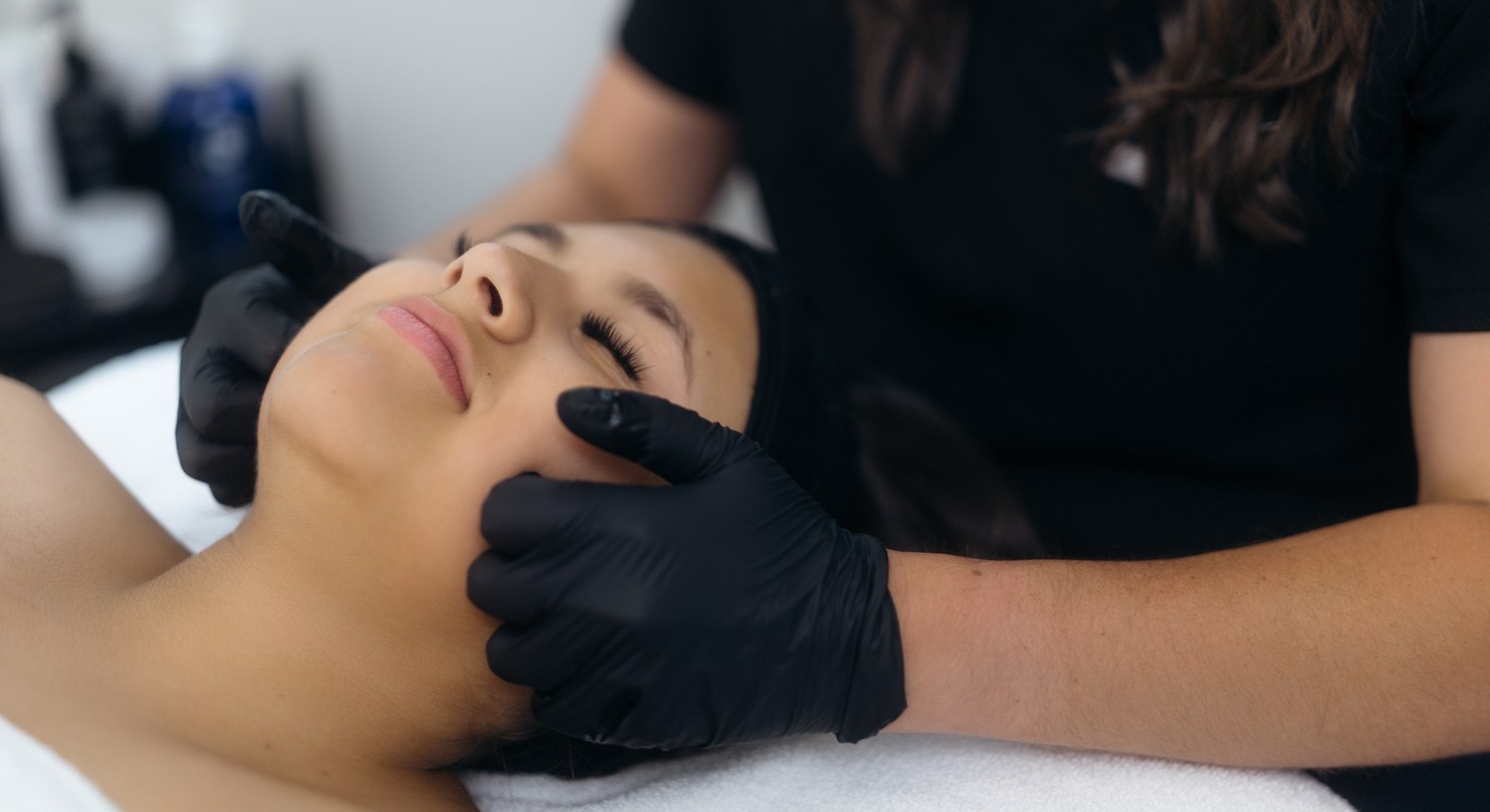Esthetician performing a facial treatment on a client