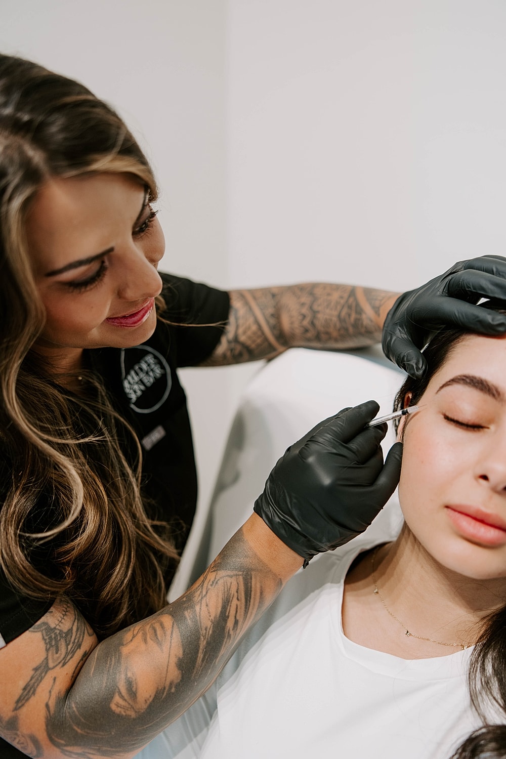 Beauty professional providing treatment to client.